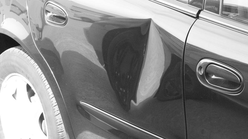 Before image of large dent on passenger door
